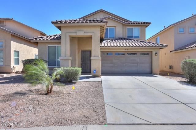 view of front of house featuring driveway, an attached garage, a tile roof, and stucco siding