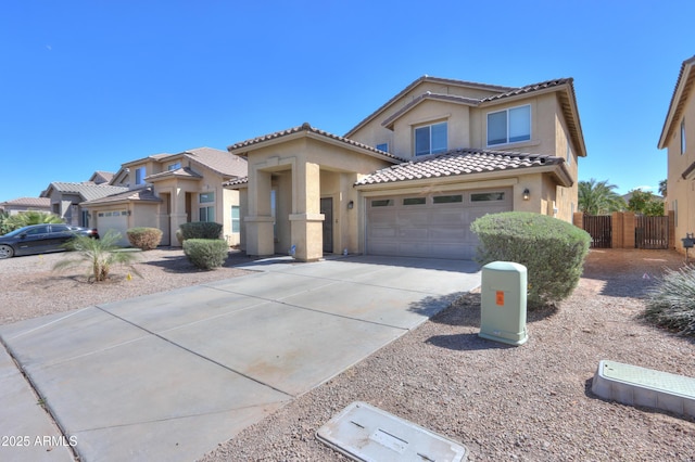 mediterranean / spanish house with concrete driveway, a tile roof, an attached garage, fence, and stucco siding