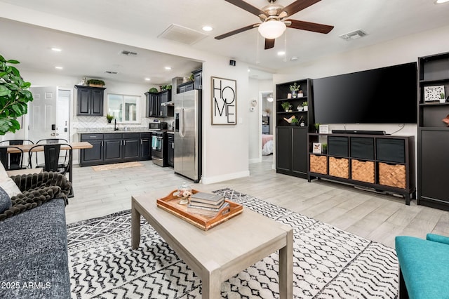 living room featuring ceiling fan and light wood-type flooring