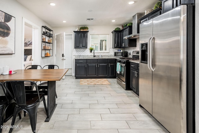 kitchen with sink, decorative backsplash, stainless steel appliances, and wall chimney exhaust hood