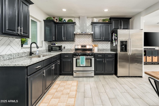 kitchen featuring sink, stainless steel appliances, tasteful backsplash, light stone countertops, and wall chimney exhaust hood