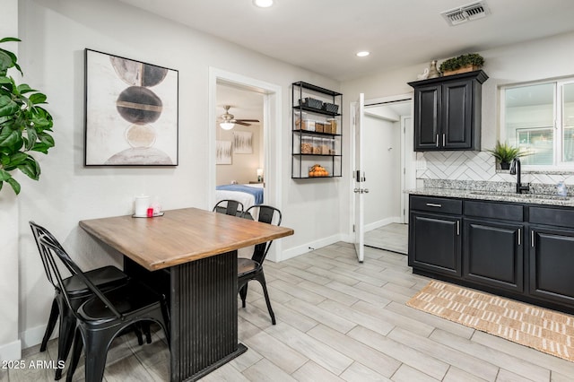 dining room with sink, ceiling fan, and light wood-type flooring