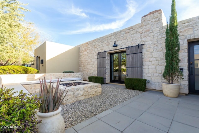 property entrance with a patio and french doors