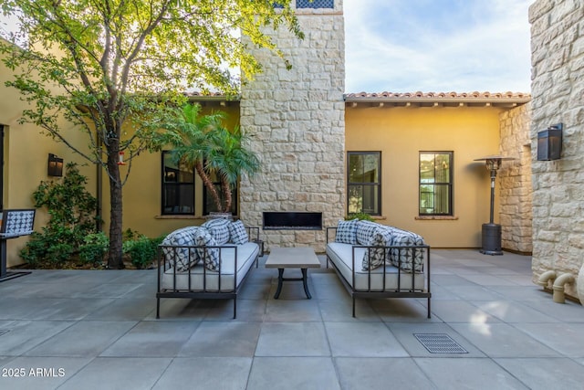 view of patio with an outdoor living space with a fireplace