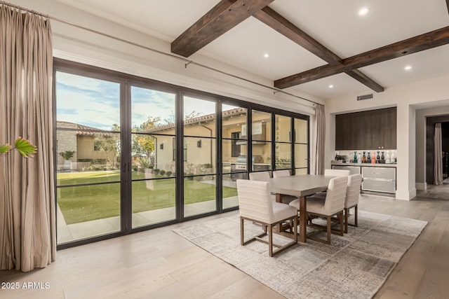 sunroom / solarium with beamed ceiling and bar area