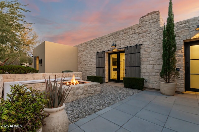 exterior entry at dusk with a patio