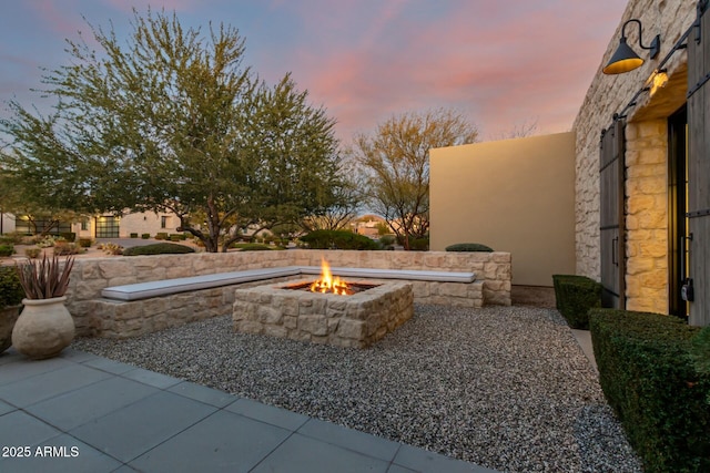 yard at dusk with a fire pit and a patio area