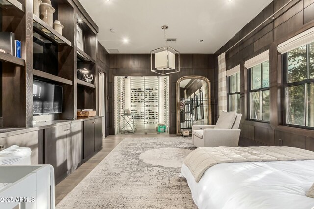 bedroom with wooden walls and light hardwood / wood-style floors