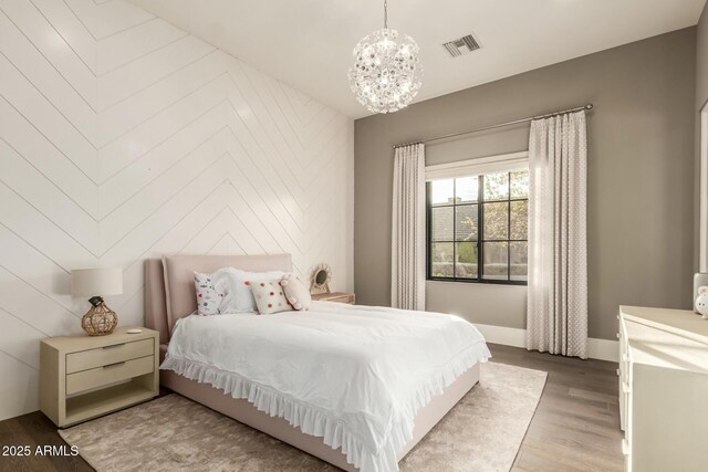 bedroom with a notable chandelier and wood-type flooring