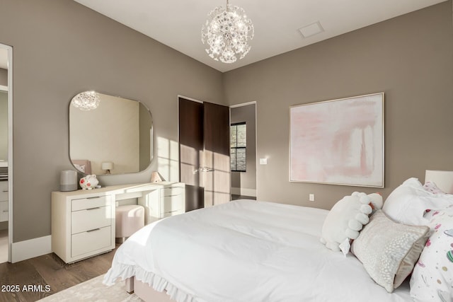 bedroom with a notable chandelier and dark wood-type flooring