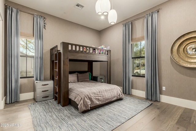 bedroom with multiple windows and light wood-type flooring