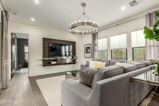 living room with hardwood / wood-style floors and an inviting chandelier