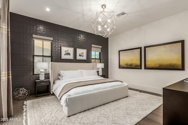 bedroom featuring a chandelier and hardwood / wood-style floors