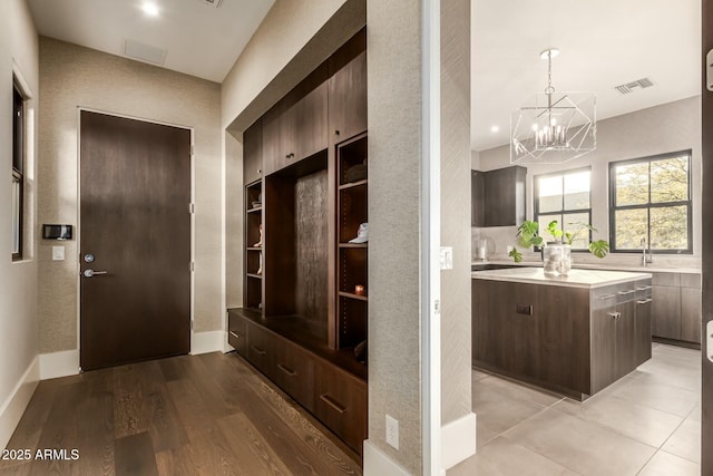 mudroom with light hardwood / wood-style floors and a chandelier