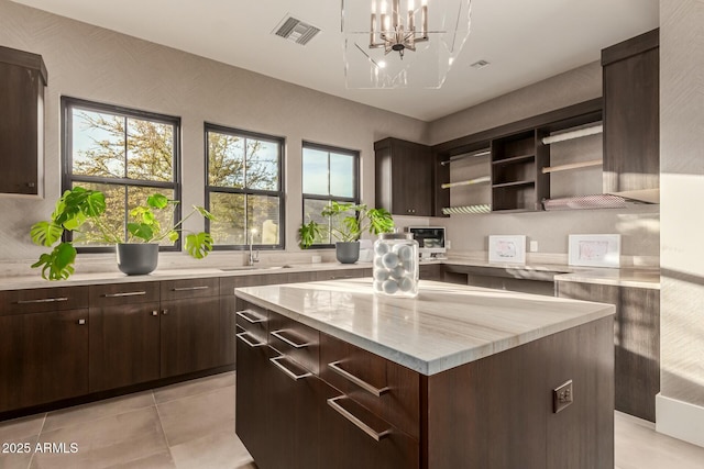 kitchen featuring dark brown cabinets, sink, and a kitchen island