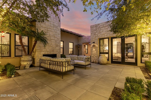 patio terrace at dusk with outdoor lounge area and french doors