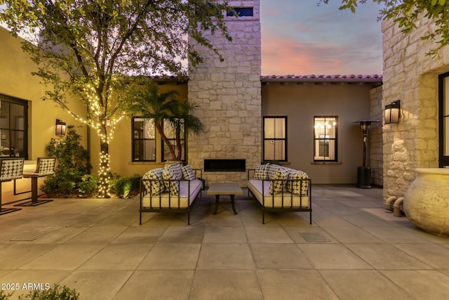 patio terrace at dusk featuring an outdoor living space