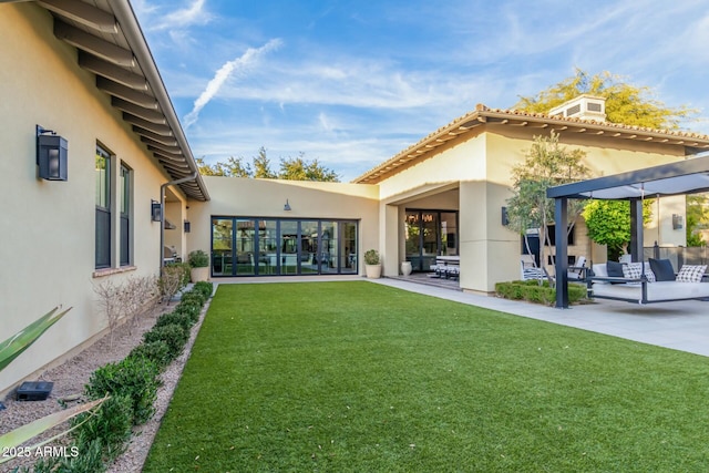 back of house featuring a pergola, a lawn, and a patio