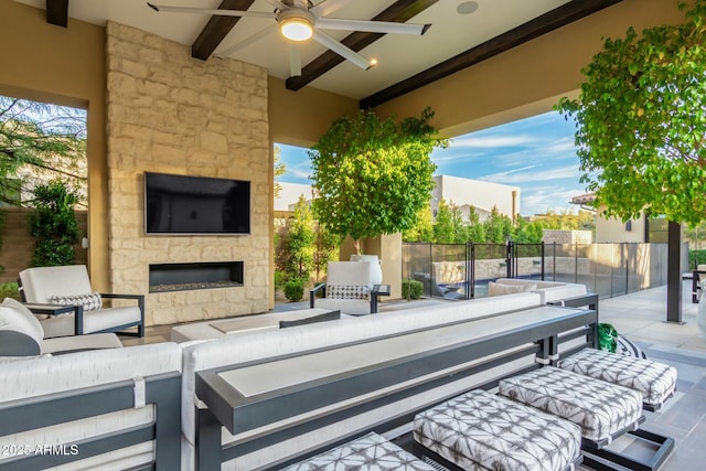 view of patio with ceiling fan and an outdoor living space with a fireplace