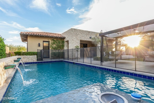 view of swimming pool with pool water feature and a jacuzzi