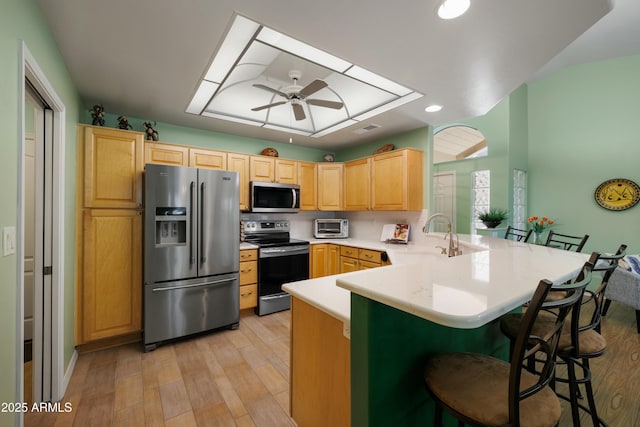 5830 E Mckellips Rd Unit 2, Mesa, AZ 85215 - kitchen with stainless steel appliances, a peninsula, light brown cabinets, a sink, and light wood-type flooring
