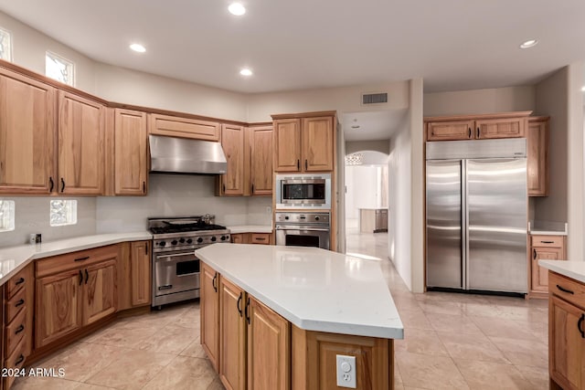 kitchen with built in appliances, a center island, and light tile patterned flooring