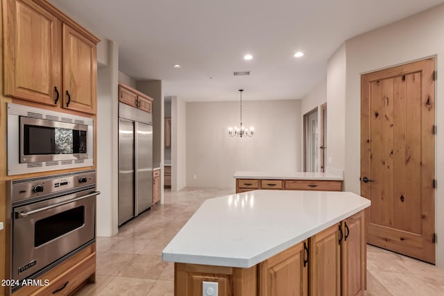 kitchen with decorative light fixtures, built in appliances, light tile patterned floors, a notable chandelier, and a kitchen island