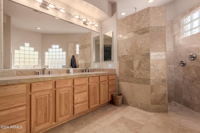 bathroom with a tile shower and vanity