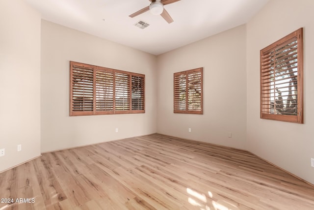 empty room featuring light hardwood / wood-style floors, a wealth of natural light, and ceiling fan