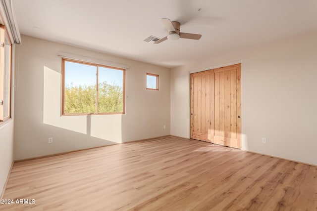 unfurnished bedroom featuring ceiling fan, a closet, and light hardwood / wood-style floors