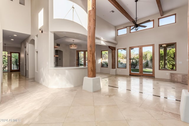 interior space with ceiling fan, beam ceiling, decorative columns, and french doors