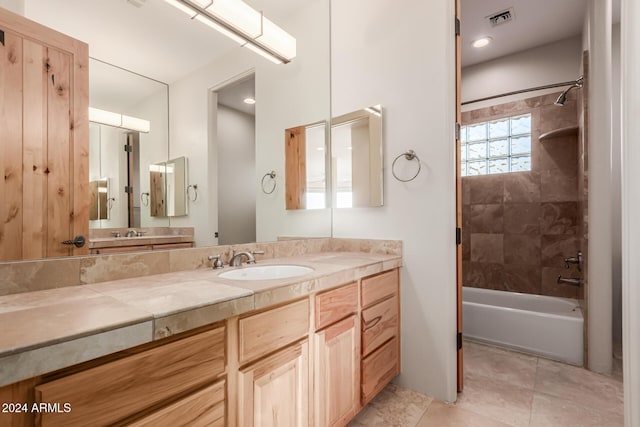 bathroom with vanity, tiled shower / bath combo, and tile patterned flooring