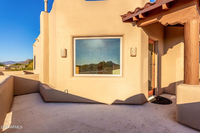 view of side of property with a mountain view and a balcony