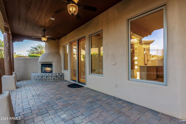 view of patio / terrace with ceiling fan and exterior fireplace