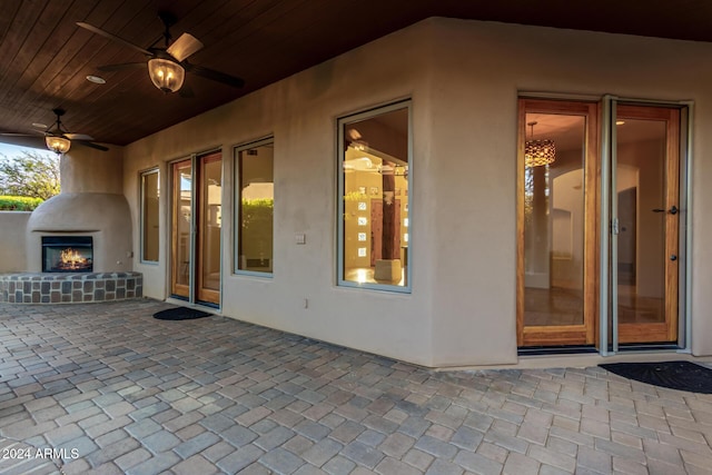 view of patio with ceiling fan and an outdoor fireplace