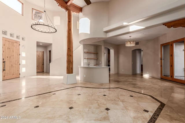 interior space with a towering ceiling and a notable chandelier