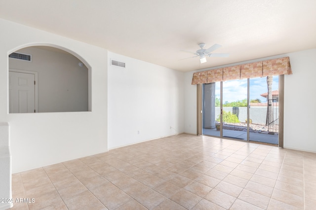 tiled empty room featuring ceiling fan