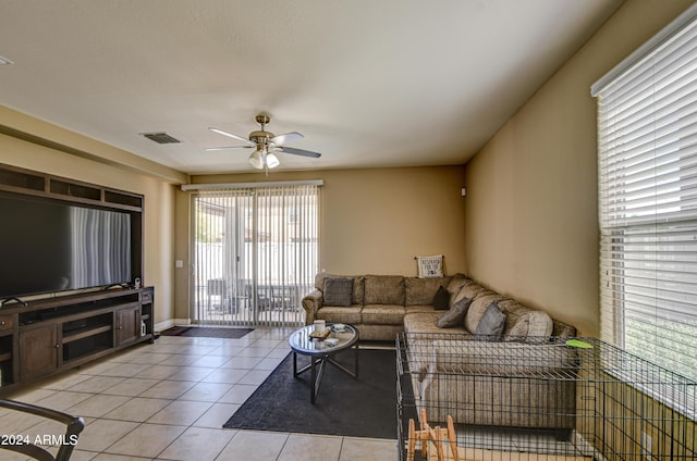 living room with light tile patterned floors, visible vents, and a ceiling fan