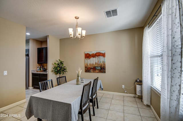 dining room with light tile patterned floors, visible vents, baseboards, and a chandelier