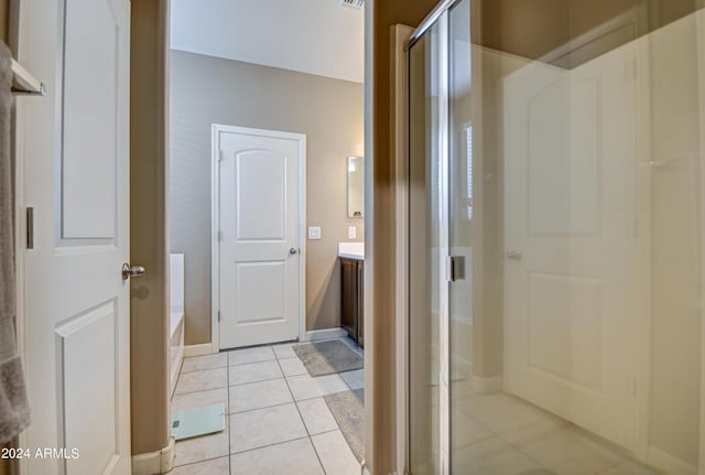 bathroom featuring vanity, baseboards, a shower stall, tile patterned floors, and a bath