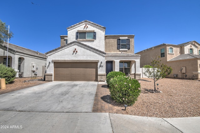 view of front facade featuring stucco siding, a tiled roof, concrete driveway, and a garage