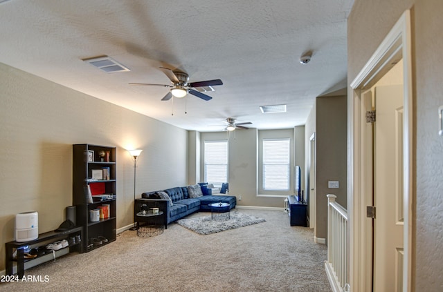 carpeted living area with visible vents, a textured ceiling, and baseboards