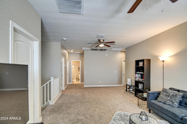 living area featuring ceiling fan, baseboards, visible vents, and light carpet