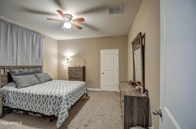 carpeted bedroom with visible vents, baseboards, and a ceiling fan