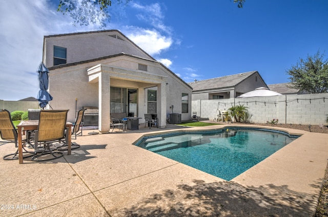 view of pool featuring outdoor dining space, a fenced in pool, a fenced backyard, central AC, and a patio area