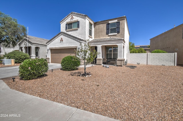 traditional-style home featuring stucco siding, concrete driveway, an attached garage, and fence