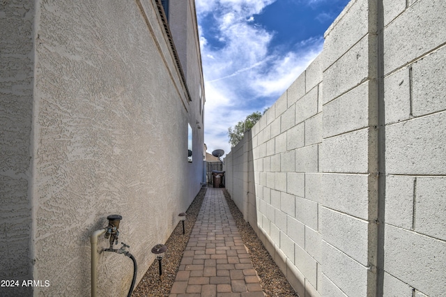 view of property exterior featuring stucco siding, concrete block siding, and fence