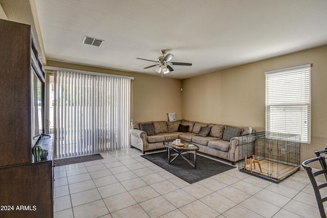 living room with light tile patterned floors, visible vents, a healthy amount of sunlight, and a ceiling fan