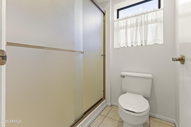 bathroom featuring tile patterned floors, toilet, and a shower stall