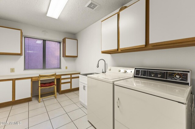 clothes washing area featuring independent washer and dryer, cabinet space, a sink, a textured ceiling, and light tile patterned flooring